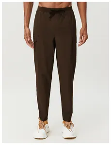 Détail du pantalon cargo marron pour homme avec poches multiples et cordon de serrage