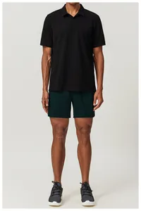 Full shot of an athletic model wearing a black breathable Polo shirt and dark green shorts