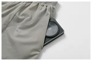 Detailansicht grauer atmungsaktiver Mesh-Sportshorts mit Fokus auf die tiefe Seitentasche