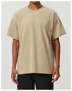 Detalle del tejido de algodón beige transpirable en una camiseta de corte holgado para hombre