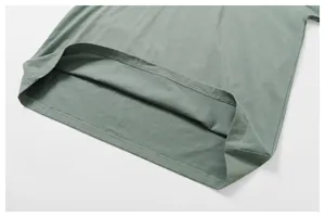 Primer plano del dobladillo de doble costura de una suave camiseta de algodón en color verde salvia.