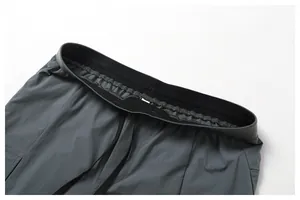 Détail en gros plan montrant la taille élastiquée et le cordon de ce pantalon cargo.