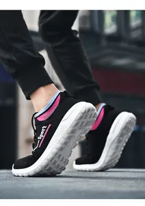 Nahaufnahme der atmungsaktiven schwarzen Fly-knit-Sneaker mit flexibler weißer Sohle
