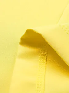 Macro view of bright yellow fabric texture showing detailed hem stitching on a blazer