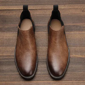 Top-down view of men's burnished brown Chelsea boots on a rustic wooden background.