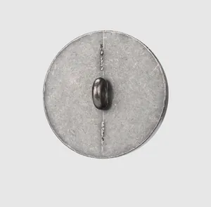 Vue détaillée de l'arrière d'un bouton métallique vintage montrant l'attache à queue