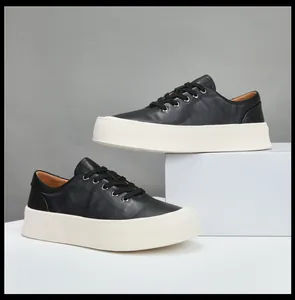 Vue détaillée de baskets à plateforme en cuir noir sur des blocs d'exposition minimalistes