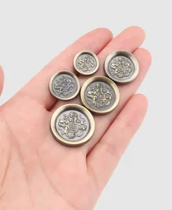 Vue détaillée de boutons en métal vintage ornés d'un blason héraldique de lion en relief
