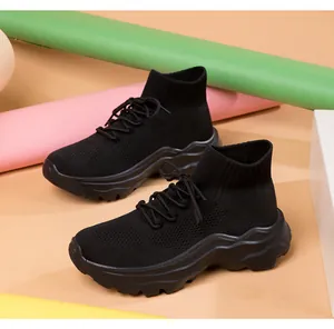 Detailed view of black breathable fly-knit high-top sneakers with thick soles