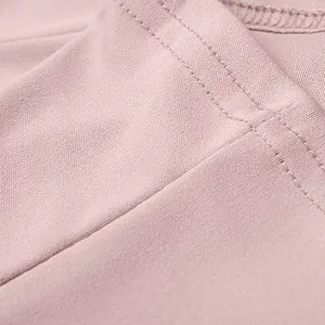 Detailed macro shot of pink blazer fabric showing neat stitching and fine texture.