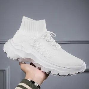 Macro view of white high-top fly-knit sneakers featuring thick chunky wavy rubber soles.