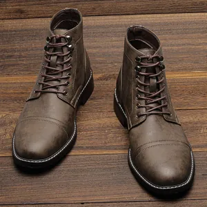 Detailansicht brauner Herren-Arbeitsstiefel mit Vintage-Finish auf rustikalem Holzboden.