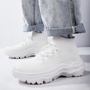 Close-up detail of white fly-knit high-top sneakers with thick wavy soles