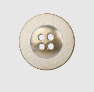 Gros plan d'un bouton en métal bronze vintage haut de gamme avec quatre trous pour vêtements.