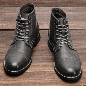 Primo piano della trama grigia vintage degli stivali da uomo su pavimento in legno.