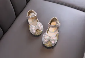 Detaillierte Ansicht goldener Glitzerschuhe für Mädchen mit zarten Mesh-Schleifen