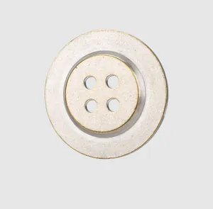 Close-up of a premium vintage two-tone silver and gold 4-hole metal button for clothing