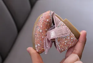 Nahaufnahme der Flexibilität eines rosa Prinzessinnenschuhs mit Strass für Mädchen
