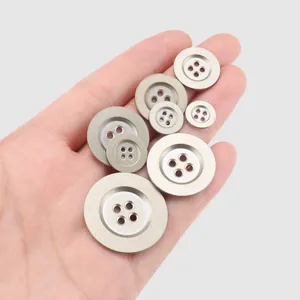 High-quality round metal buttons for clothing in various sizes held on a palm.