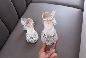 Detalle elegante de zapatos de princesa para niñas con lazo de diamantes y perlas
