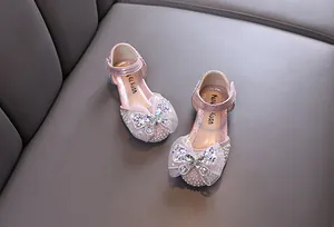 Detail von rosa Mädchen Prinzessinnenschuhen mit Strass-Schmetterlingsschleife und Perlen