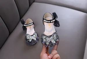 Detalle de zapatos de princesa negros para niña con pedrería y perlas