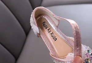 Detailansicht eines rosa glitzernden Prinzessinnenschuhs mit elegantem Perlenbesatz