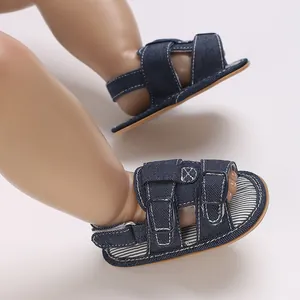 Nahaufnahme von dunkelblauen Denim-Babysandalen mit Doppelschnallen und Streifenfutter.