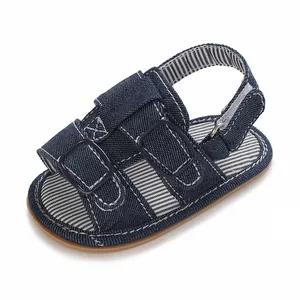 Nahaufnahme von blauen Denim Baby-Sandalen mit gestreiften Einlegesohlen und Schnallen