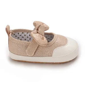Detailed view of rose gold baby girl pre-walker shoe with a classic bow design