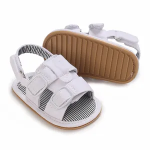Detailansicht weißer Segeltuch-Sandalen für Jungen mit rutschfester Sohle und Streifen.