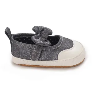 Side profile view of grey sparkle baby girl shoes featuring a bow and soft walker sole.