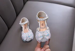 Close-up of silver princess shoes for girls with glitter and butterfly lace bow