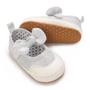 Detailed view of silver infant pre-walker shoes with decorative bow and non-slip sole