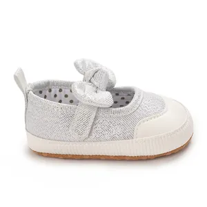Close-up of silver glitter baby girl pre-walking shoe with decorative bow and soft sole
