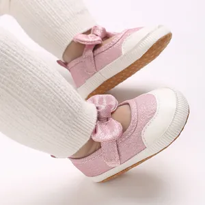 Close-up of pink glitter baby shoes with bow detail and non-slip soft sole