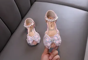 Detail of pink glitter princess shoes for girls with bow and pearl accents