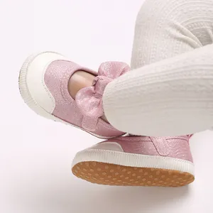 Close-up of pink glitter baby walking shoes with a soft non-slip sole and bow