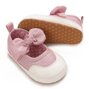 Detail view of pink baby girl walker shoes with large bow and anti-slip dotted sole