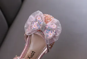 Macro detail of pink girls princess shoe featuring a sparkling rhinestone mesh bow