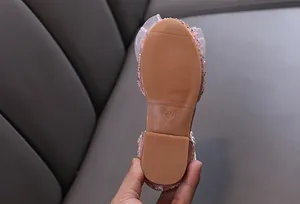Detailed view of non-slip rubber sole on girl's pink rhinestone princess dance shoe.