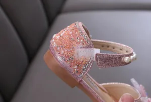 Close-up detail of girl's pink glitter princess shoe with pearls and rhinestones