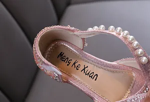 Close-up detail of pink glitter girls princess flat shoe with pearls and sparkling rhinestones