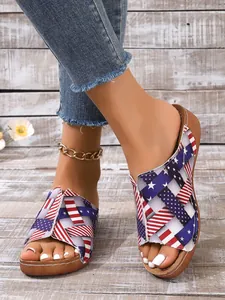 Casual women's fish-mouth slippers with US flag pattern worn on rustic wood background.