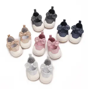 Detailed view of baby girl walking shoes with sparkling bows and soft anti-slip soles.