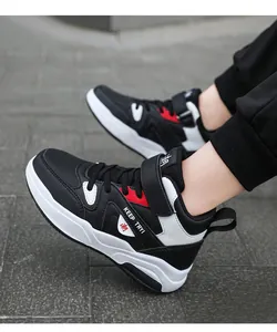 Détail latéral des baskets montantes noires et blanches pour enfants avec fermeture Velcro