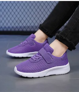 Primo piano di scarpe da corsa in mesh viola per bambine indossate con jeans neri