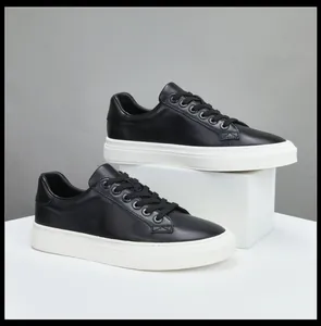 Gros plan sur des baskets haut de gamme en cuir noir pour hommes avec semelles blanches.