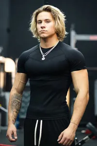 Close-up of men's black high-elasticity compression gym t-shirt on a model showing the tight fit