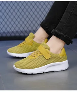 Dettaglio delle sneakers in mesh giallo traspirante per bambine con suole bianche.